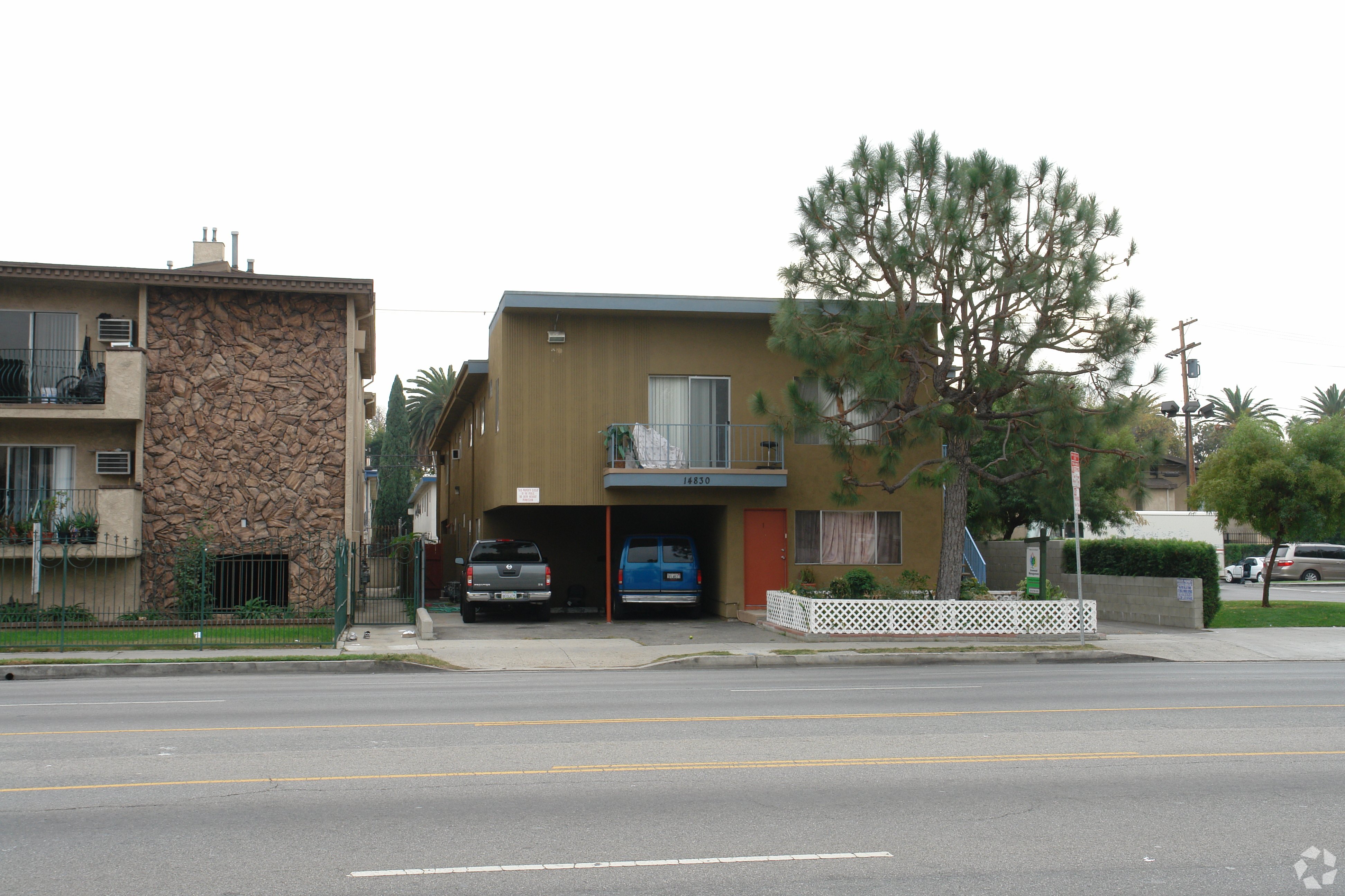 A street view of a residential area with two houses and a car parked in front of one house.